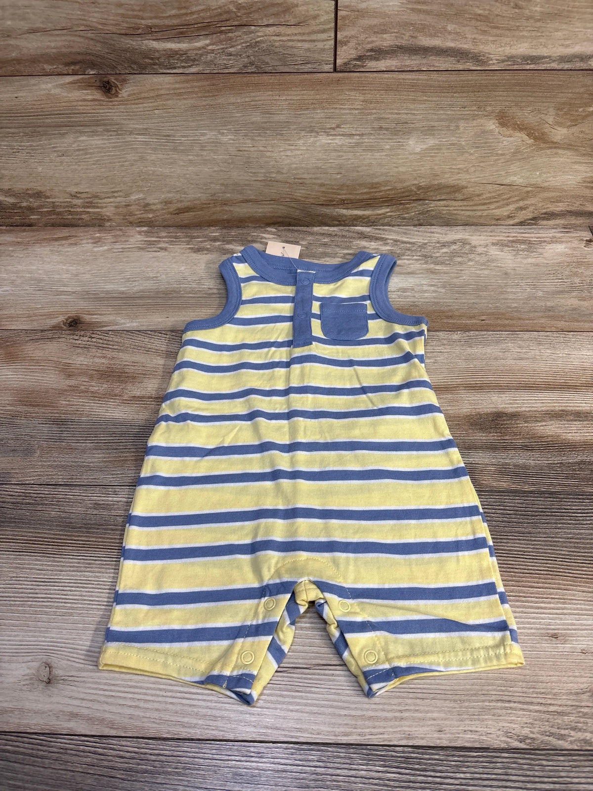 Flat lay of yellow and blue Henley romper size 12m showing chest pocket, snap placket and crotch snaps on wood
