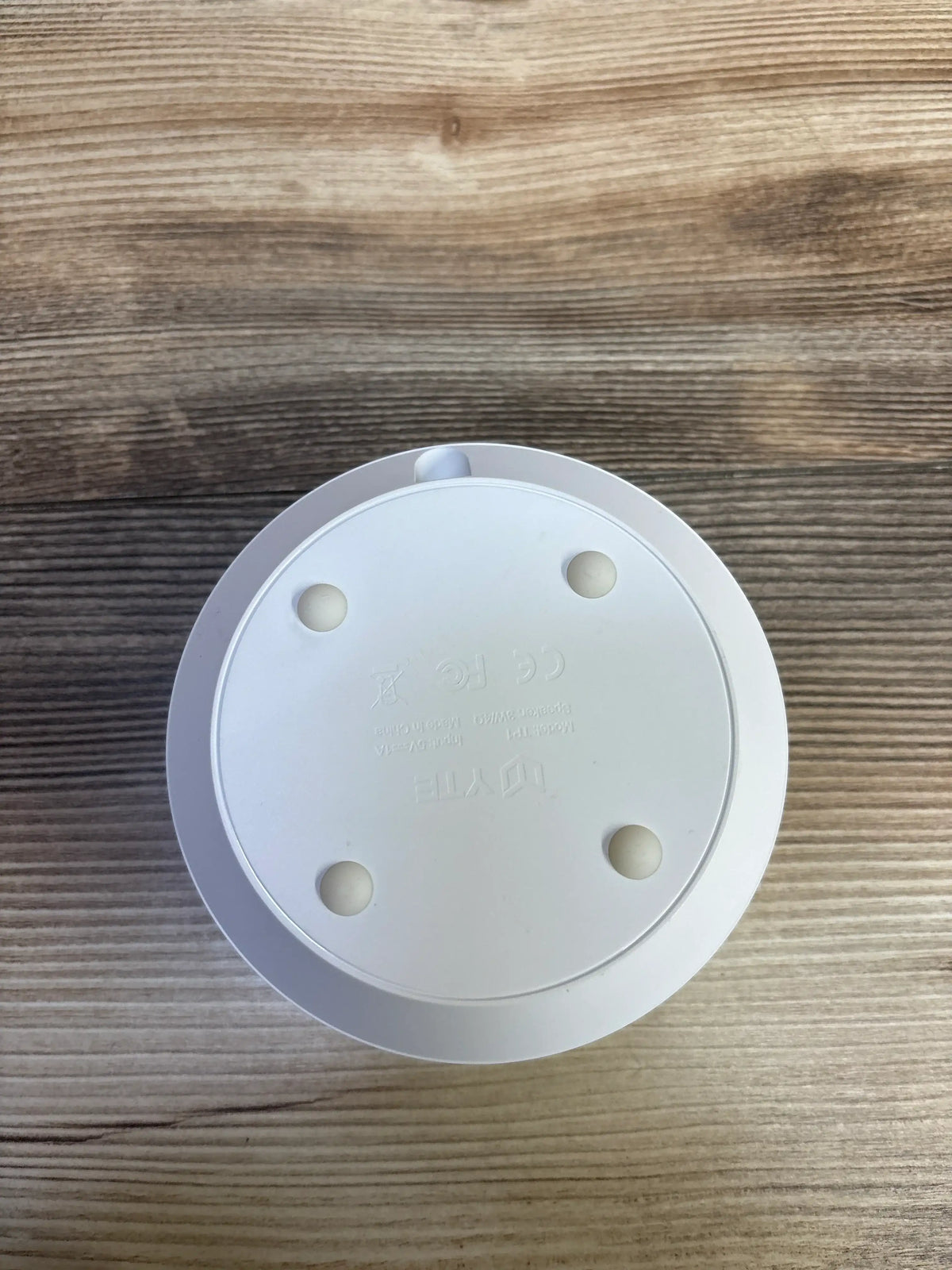 Bottom view of a white Me n Mommy To Be YTE TP1 white noise sound machine on a wooden surface.