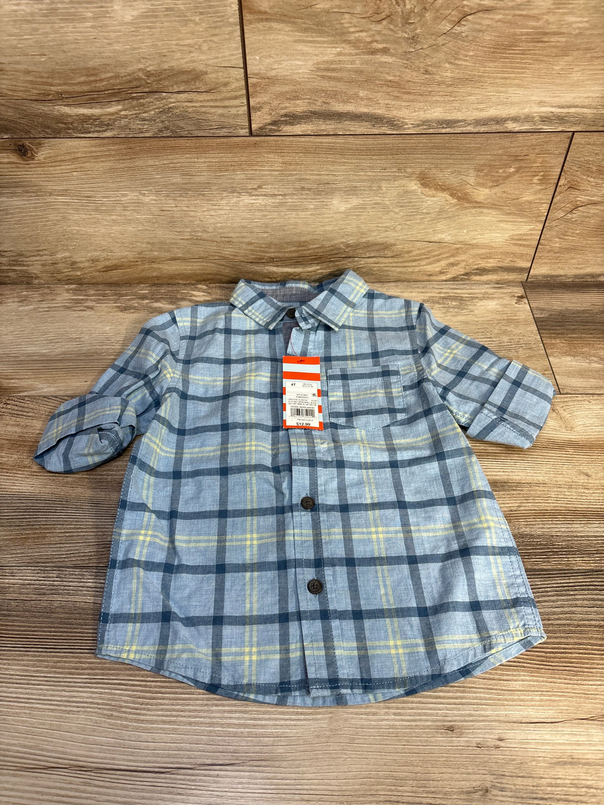 Blue and yellow plaid toddler shirt with price tag on wooden background