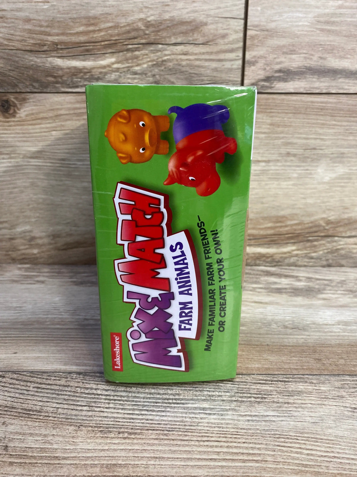 Front view of Lakeshore Mix and Match Farm Animals set of 6 showing three colorful connectable animals on wood floor