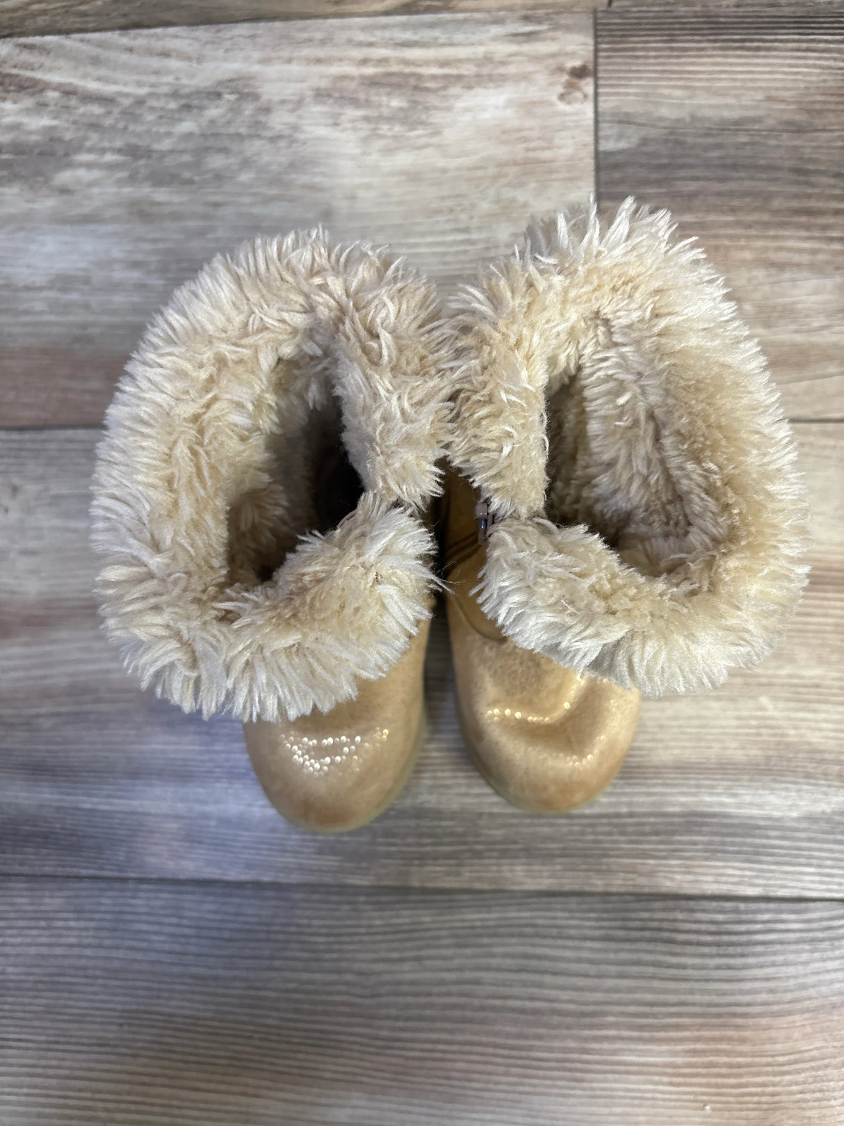 Top-down view of Cat & Jack Leah toddler winter boots in cognac showcasing plush faux-fur cuff and glittery toe on wood-floor background