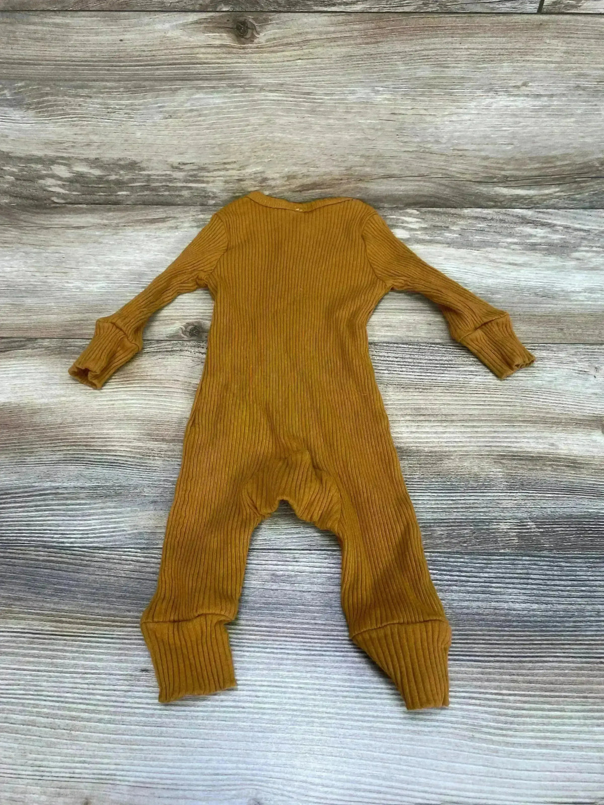 Back flat lay of brown ribbed henley coverall showing ribbed texture, long sleeves, cuffed ankles on wood background