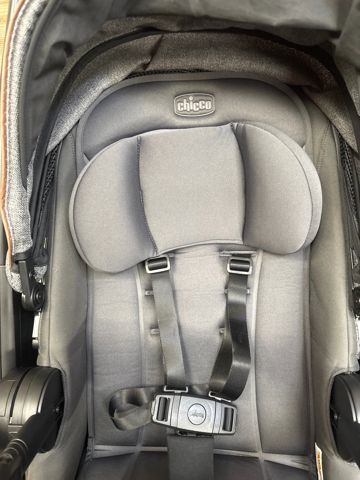 Close-up view of Chicco Corso Primo Stroller in Summit showcasing padded gray seat and harness inside the stroller