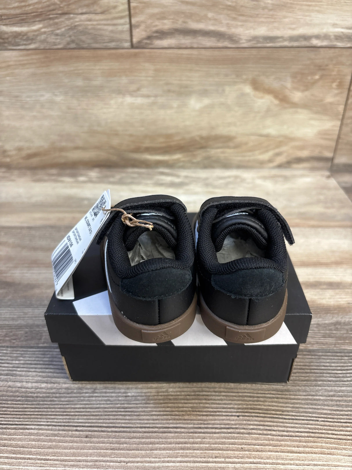 Black Adidas toddler sneakers with velcro straps, brown soles, on box with tag, kids footwear