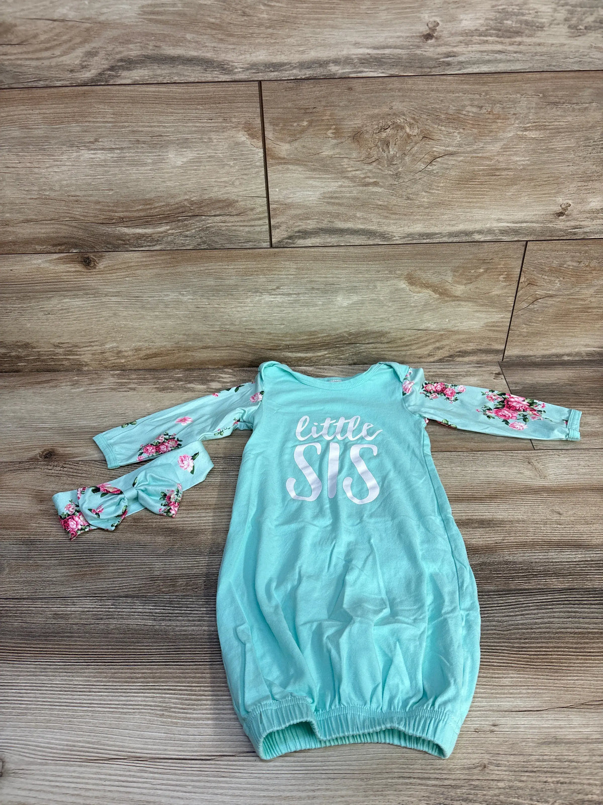 Front view of blue Little Sis 2-piece sleep gown and headband set with floral sleeves on a wood floor