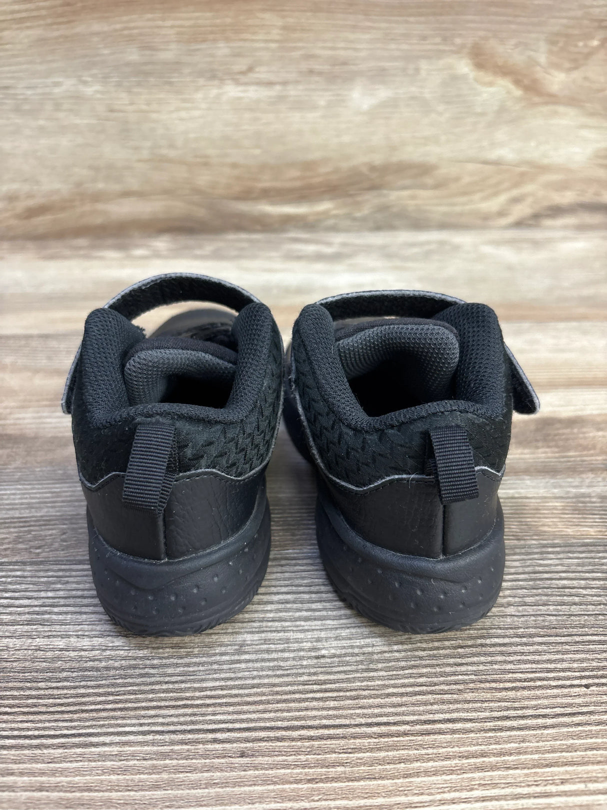 Back view of Jordan Max Aura 3 TD toddler sneakers in black anthracite showcasing padded collars and textured soles on wooden surface