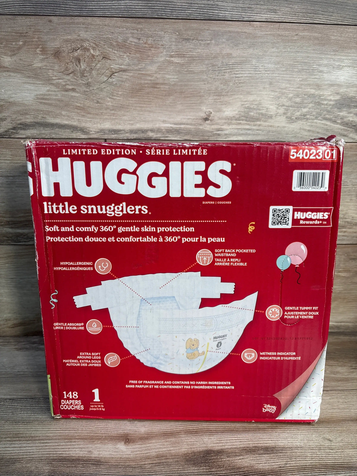 Front view of Huggies Little Snugglers diapers size 1 148 count showcasing 360 gentle skin protection on a wood surface