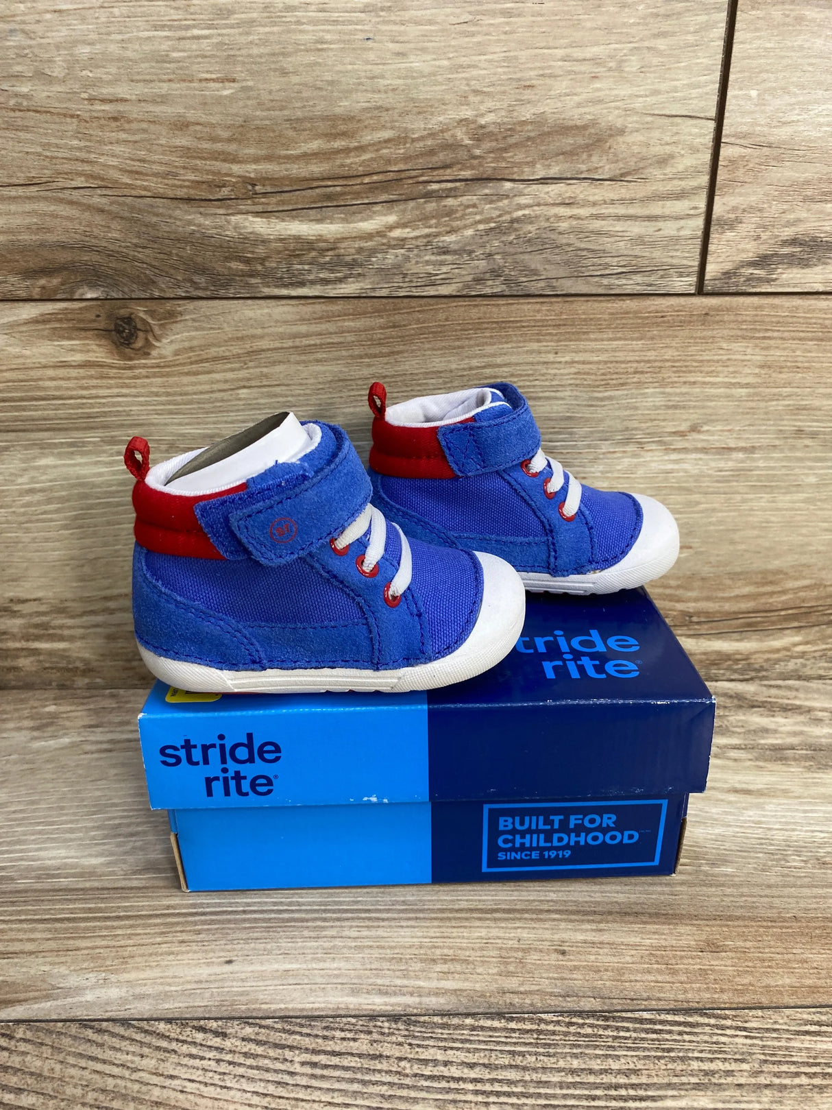 Three-quarter view of Stride Rite Soft Motion Danny toddler sneakers in blue showing Velcro strap and cushioned sole on white