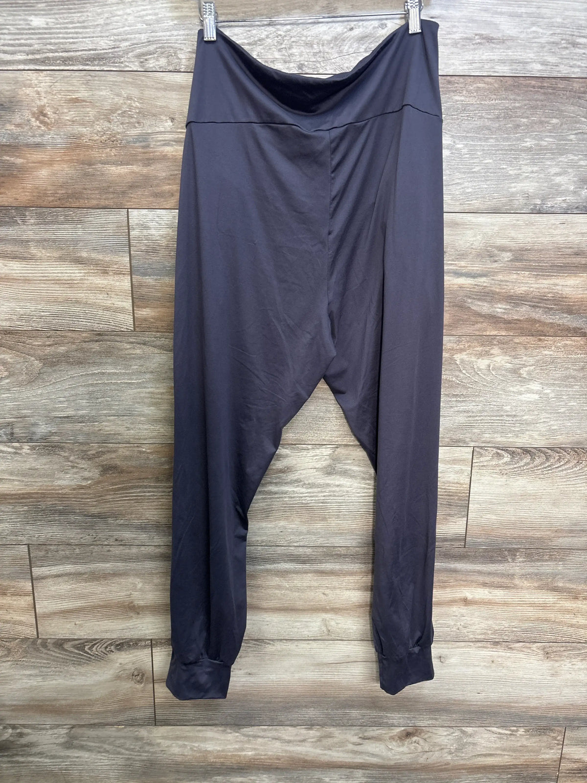 Front view of grey maternity full panel joggers showcasing the full panel and relaxed fit against a wood-look background