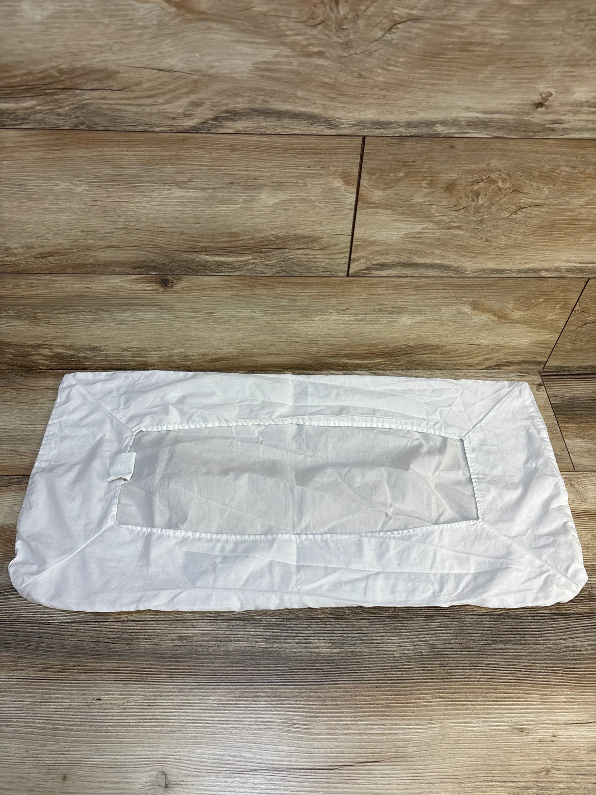 White rectangular fabric changing pad cover for babies on wood floor