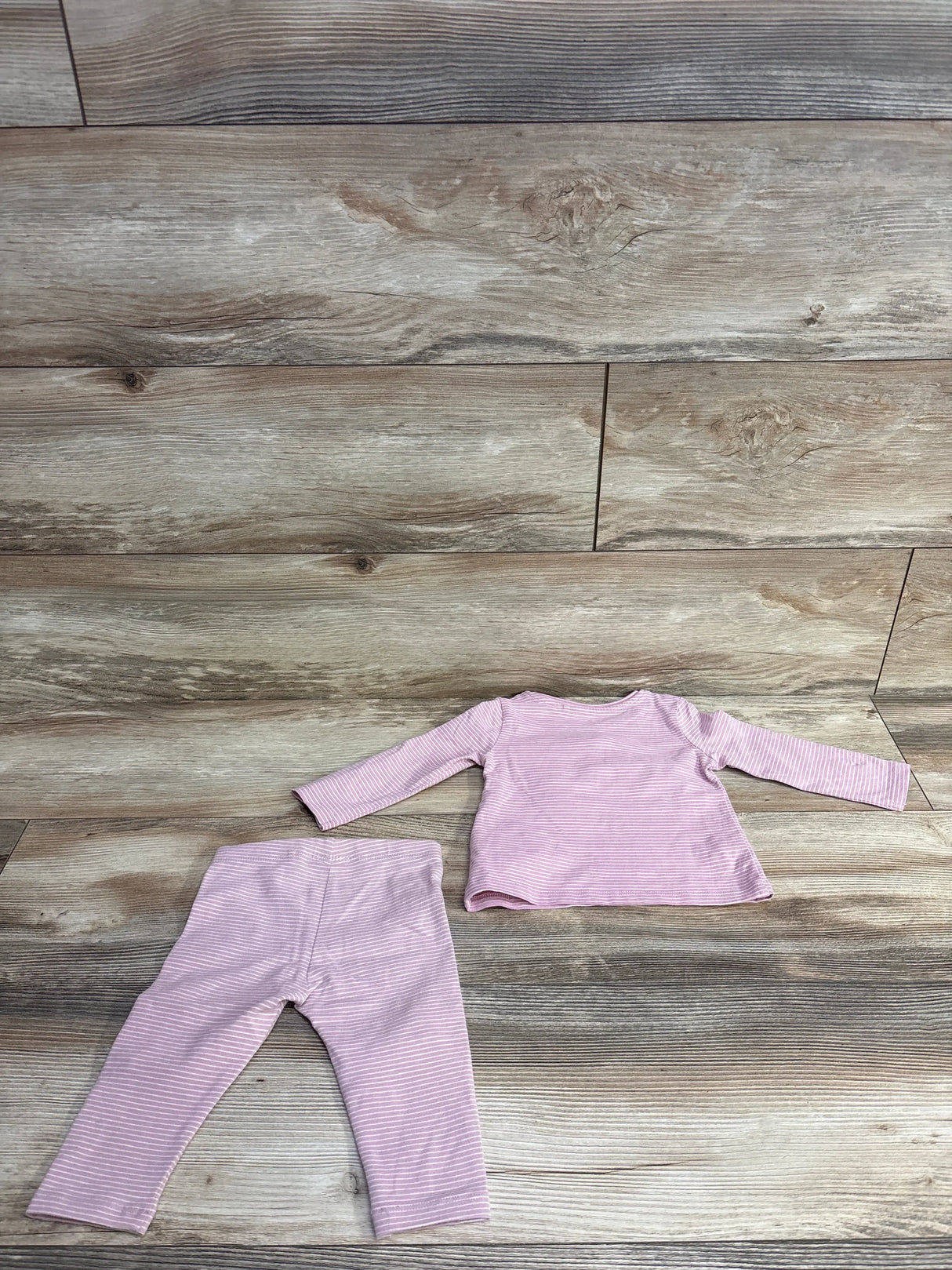 Back view flat lay of Next two piece set with pink long sleeve top and pink striped pants on wood plank floor