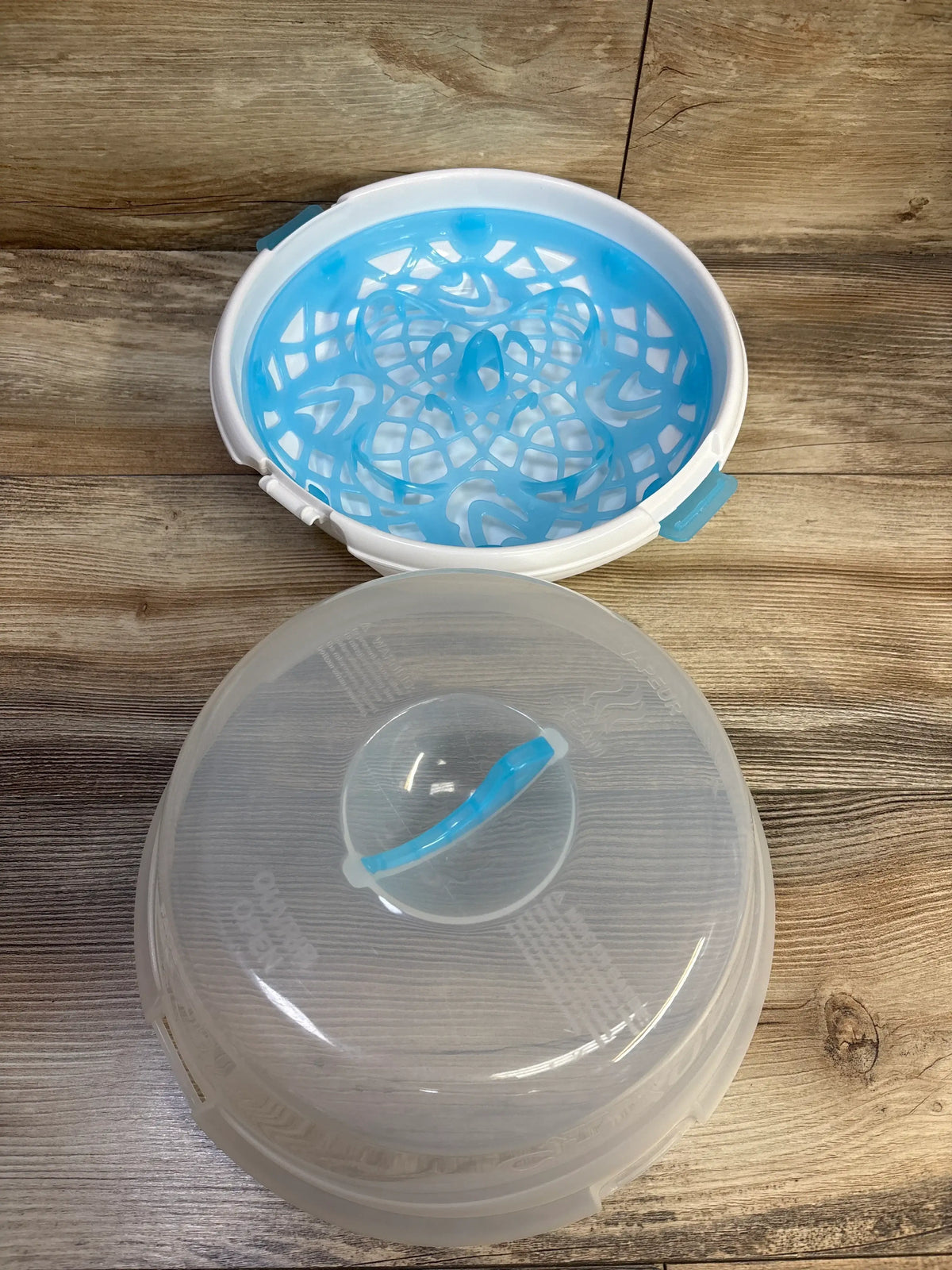 Top view of Munchkin Steam Guard microwave bottle sterilizer showing white base, blue basket, and clear lid with blue handle