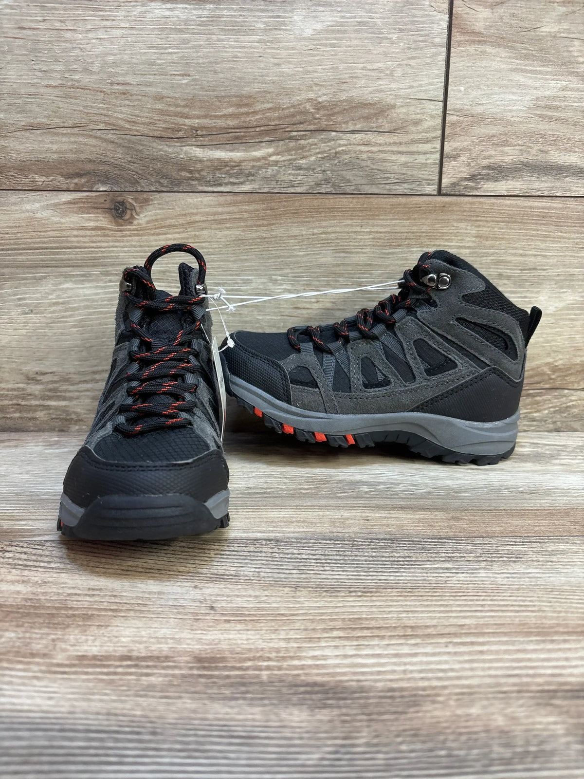 Front view of Cat and Jack Patsy kids hiking boots showcasing black and gray upper, red-accent laces, and rugged tread on wood plank floor