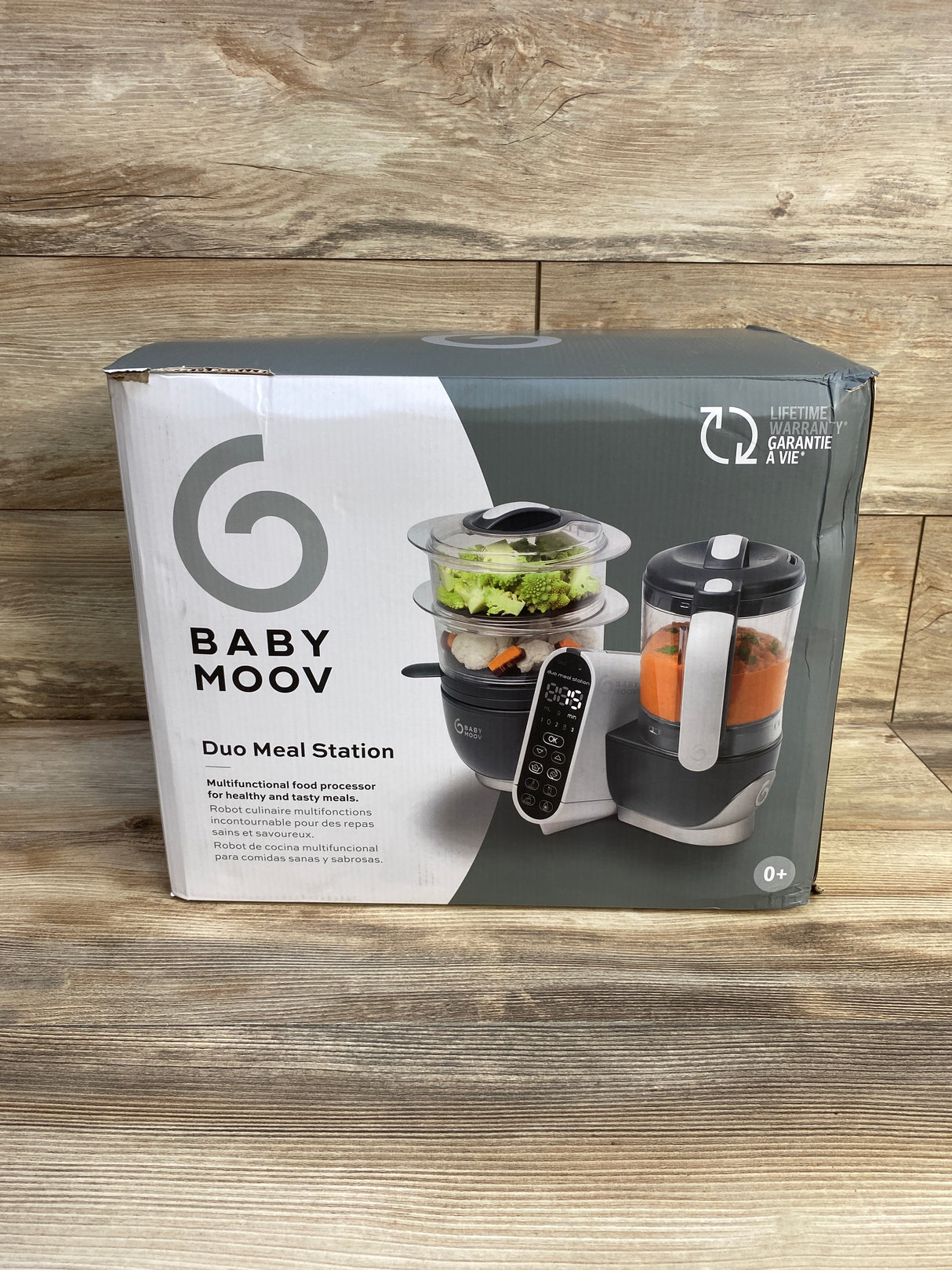 Babymoov Duo Meal Station baby food processor in box on wood floor, multifunctional steamer
