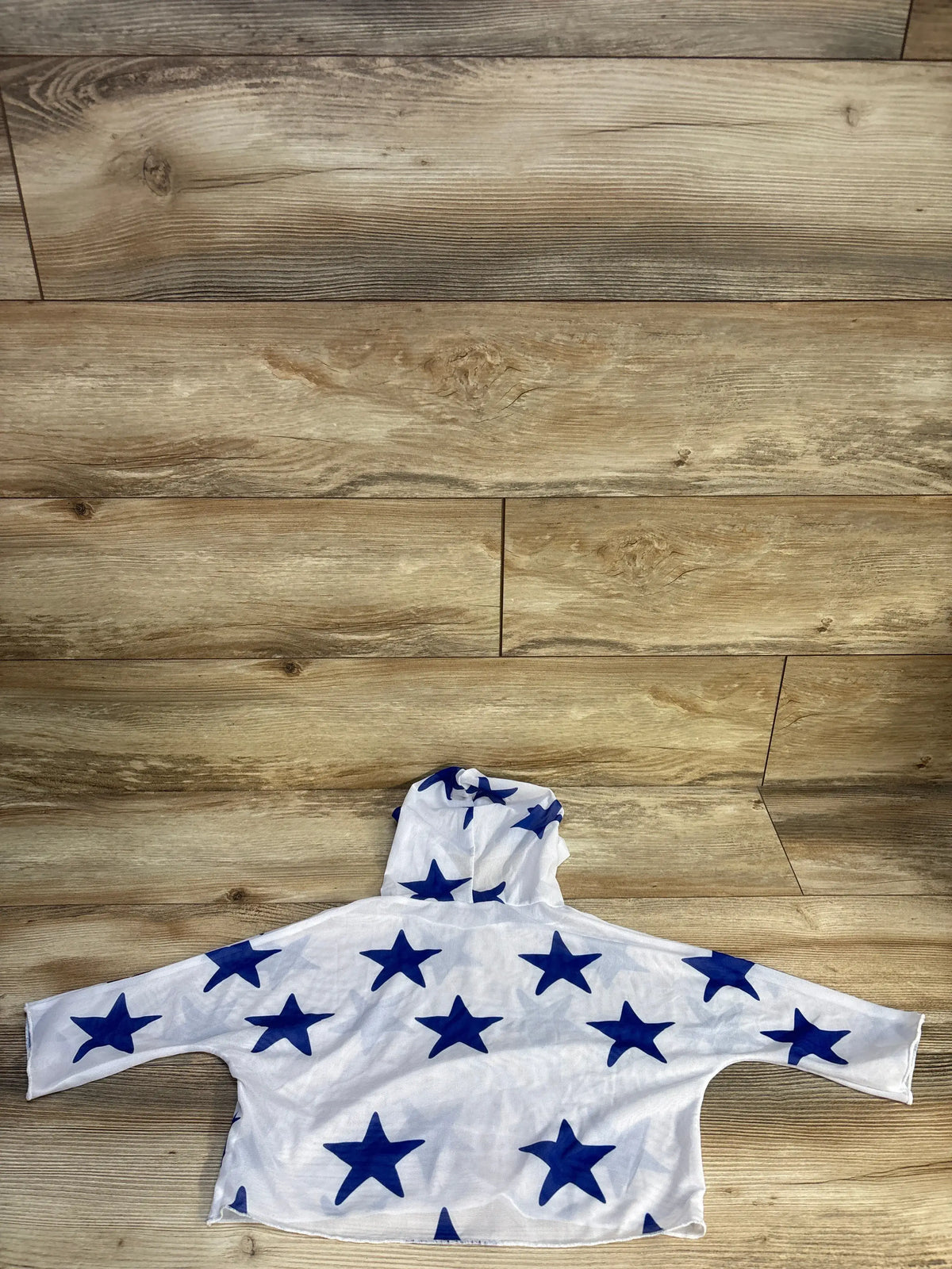 Back view of white Shein mesh hooded swim cover-up in size 4T, showcasing blue star print on a wood floor