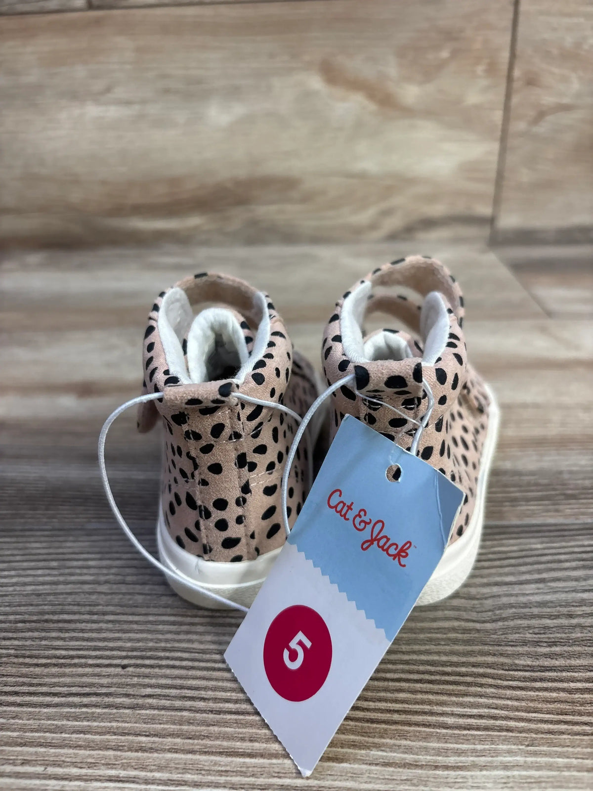 Rear view of Cat & Jack leopard high-top toddler sneakers with size 5 hang tag on wood surface
