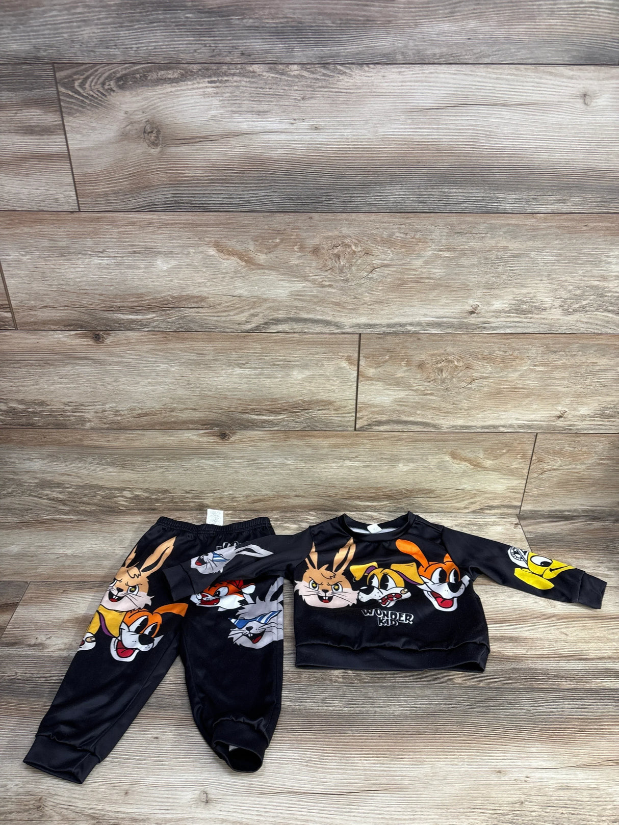 Looney Tunes toddler sweatshirt and jogger set with cartoon characters on wooden floor