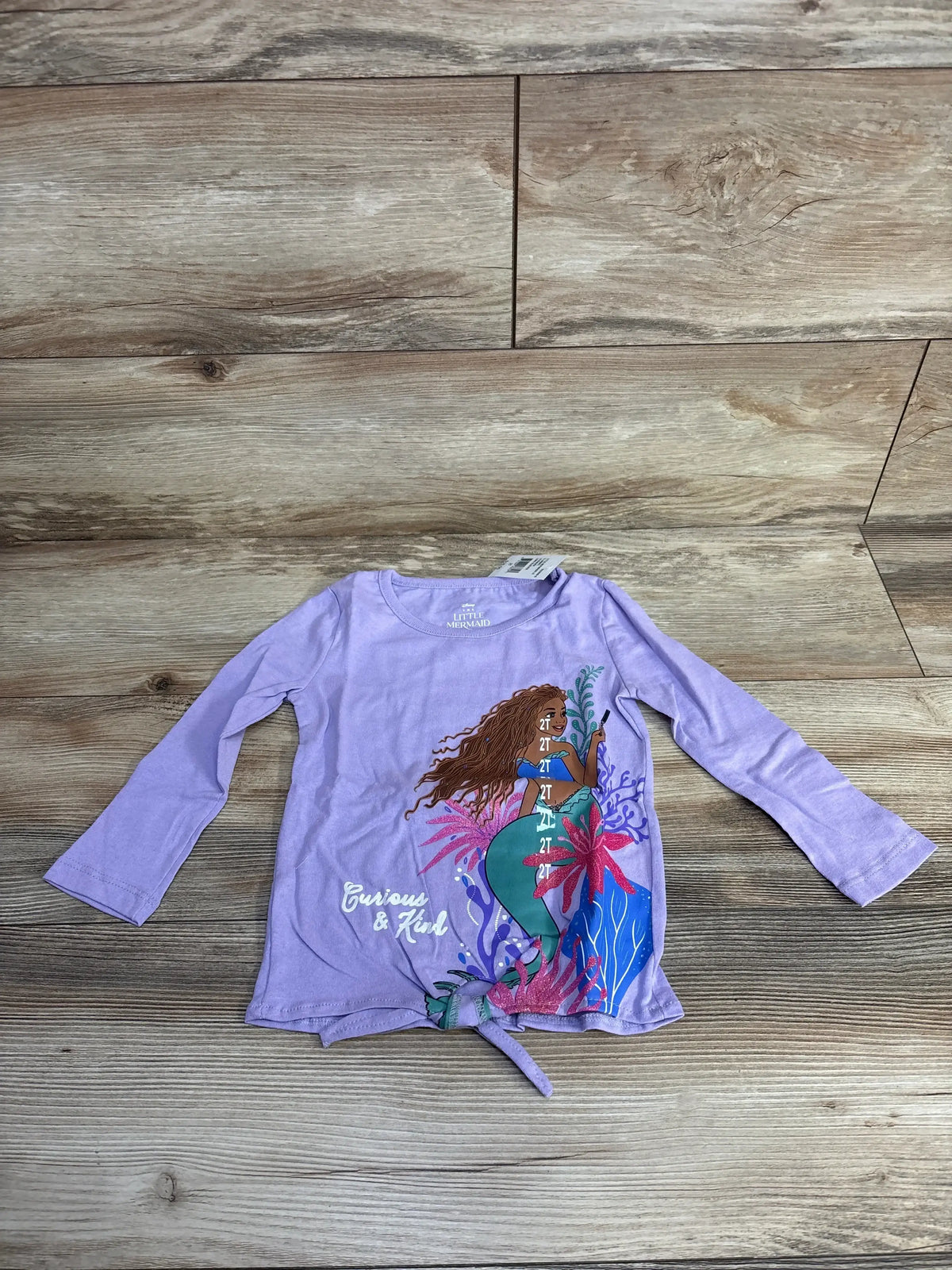 Purple long sleeve toddler shirt featuring Disney's The Little Mermaid with curly brown-haired Ariel and ocean plants