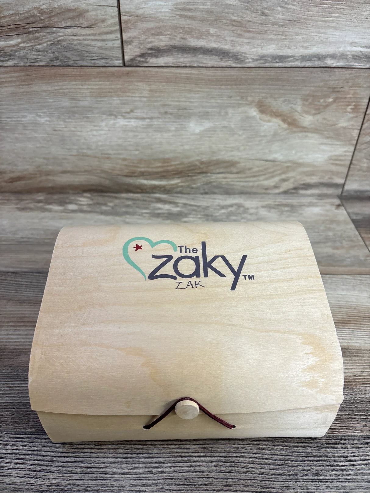 Wooden keepsake box with 'The Zaky Zak' logo on rustic wood background