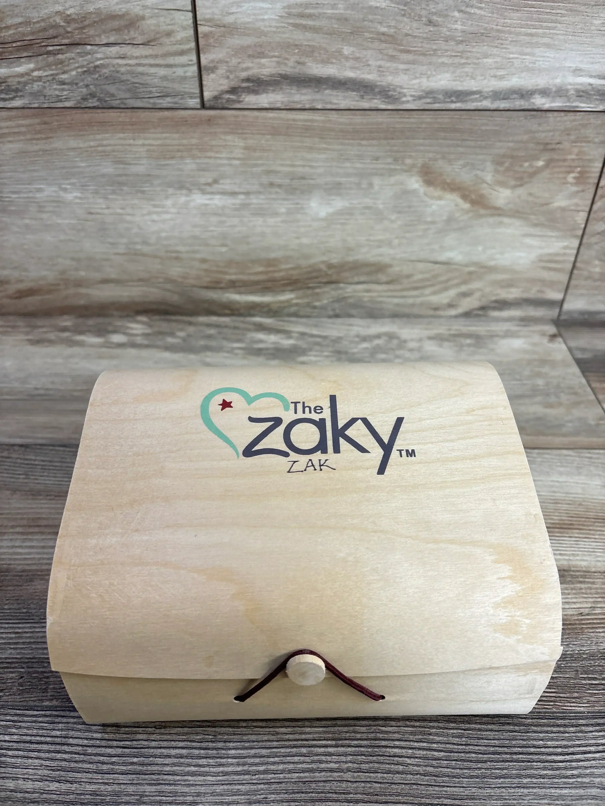 Wooden keepsake box with 'The Zaky Zak' logo on rustic wood background