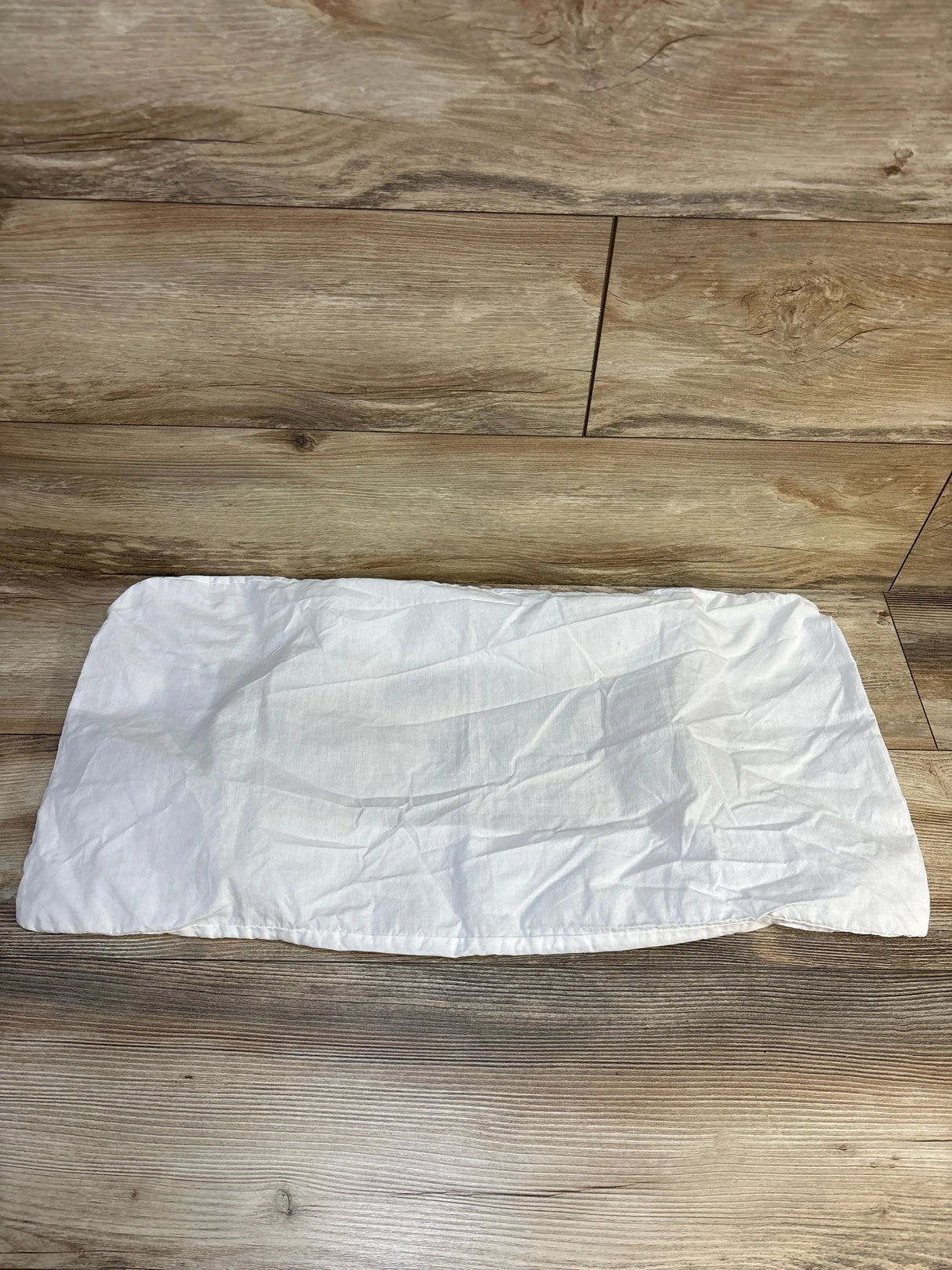 White cotton changing pad cover on wood floor, gently used baby gear