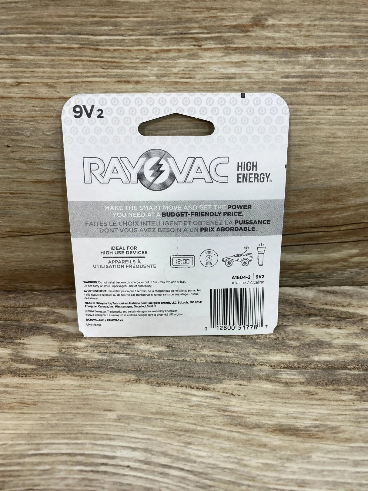 Rear view of Rayovac 9V batteries 2-pack packaging showing logo, HIGH ENERGY headline, usage icons and barcode on wood