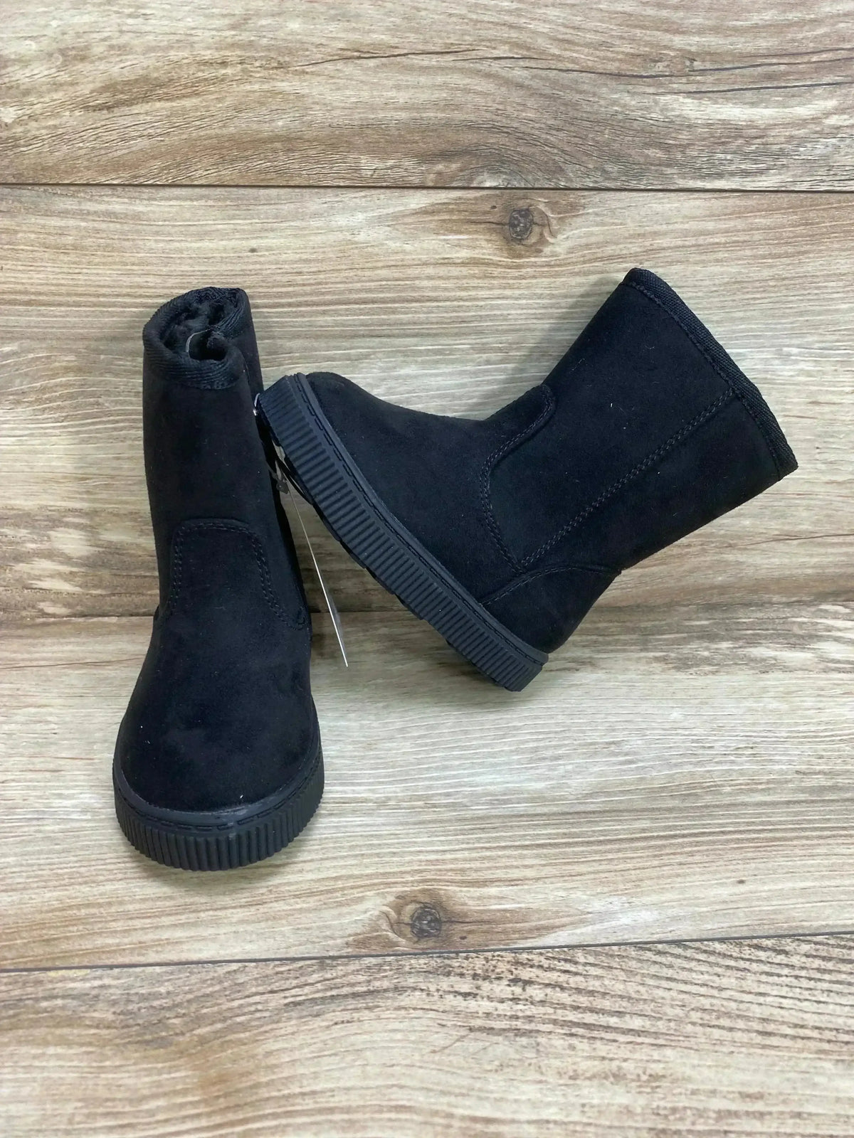 Front and side view of Cat & Jack black shearling-style zipper boots showing faux-suede upper and textured sole on wood