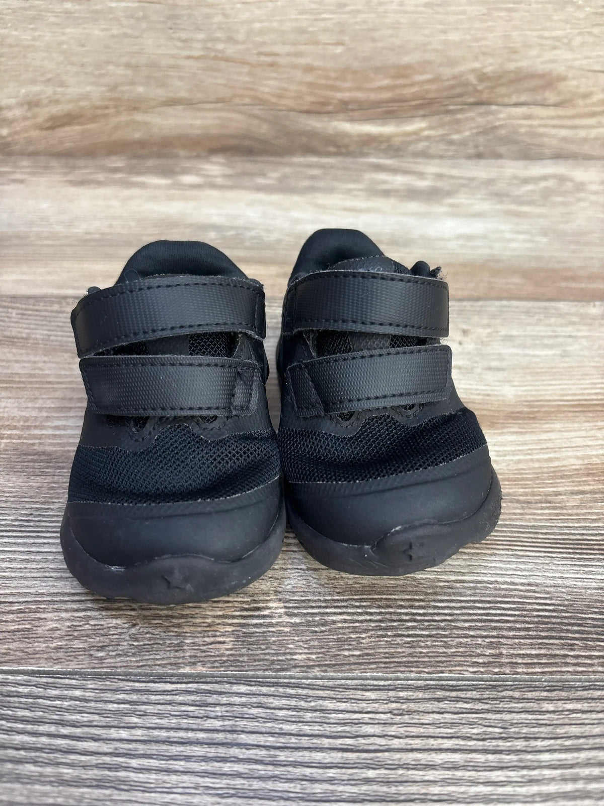 Front view of Nike Star Runner 2 TDV toddler sneakers with double Velcro straps and black mesh upper on wood floor