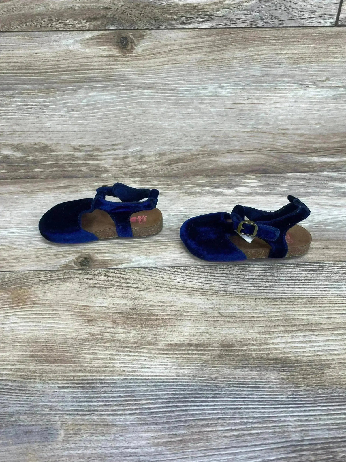 Pair side view of Baby B’gosh navy velvet cork-soled shoes showing buckle strap and cork footbed on wood background