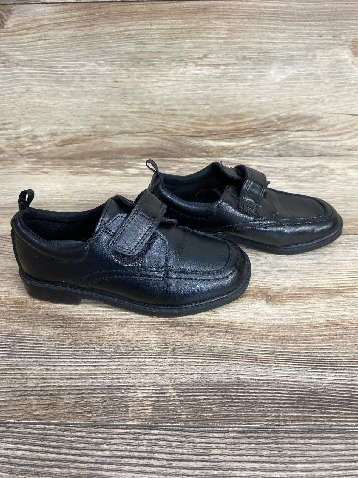 Side view of Wonder Nation Oxford black kids' dress shoes size 10C showing Velcro strap closure and stitched toe on wood background