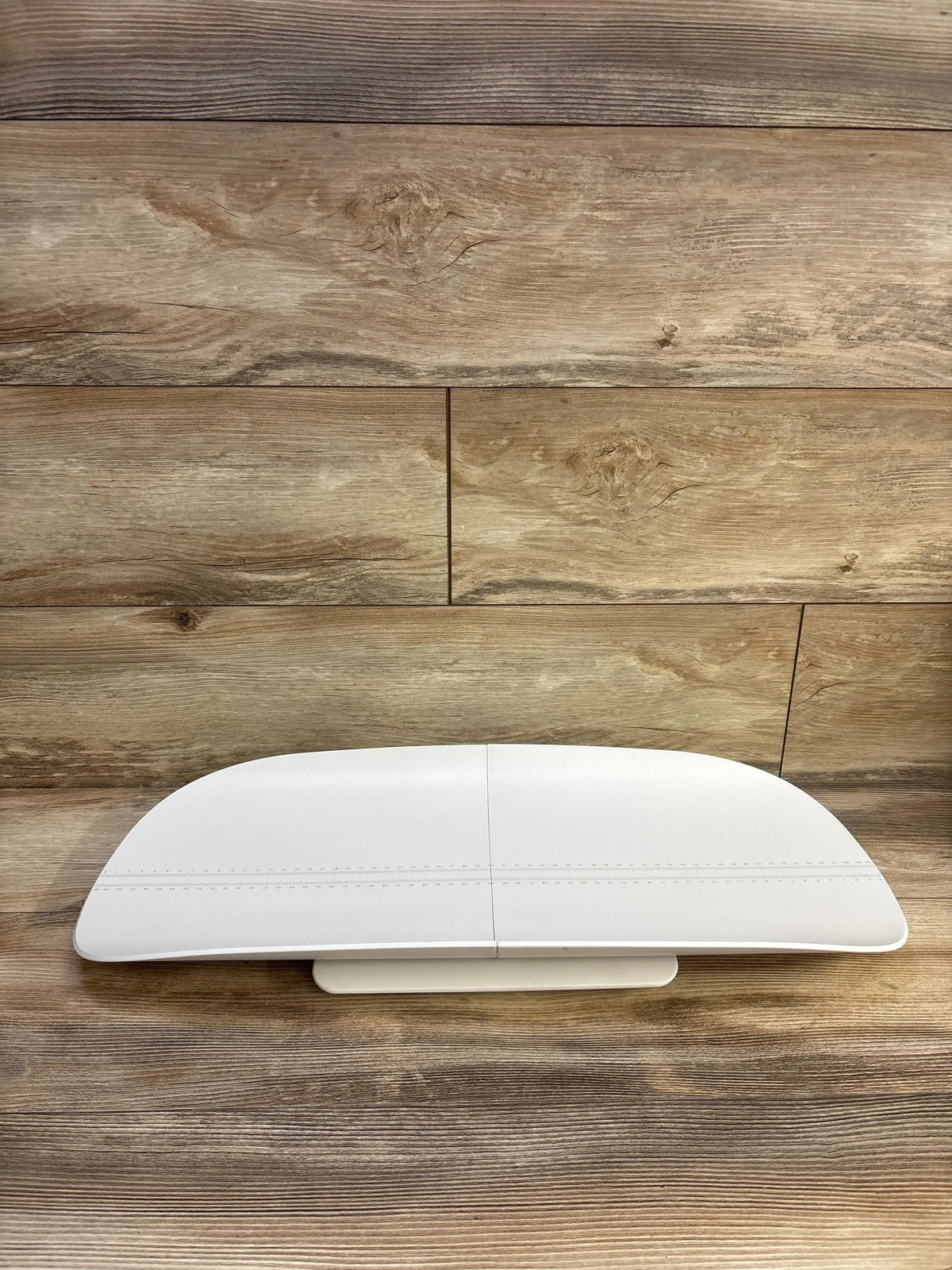 Front view of MomMed Baby Scale showcasing built-in height measurement markings with a wood background