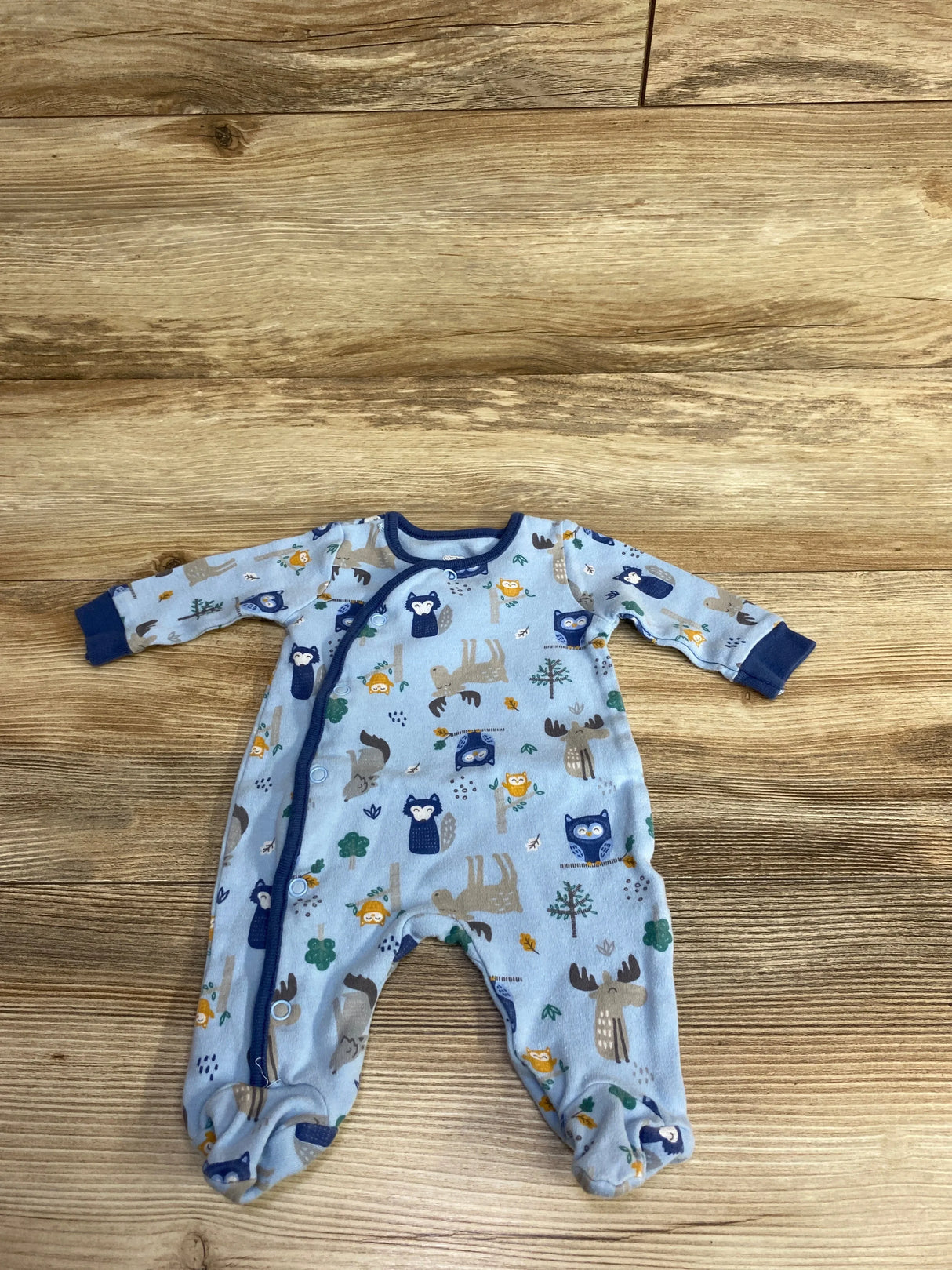 Blue infant footed sleeper with woodland animal print including owls and moose on wood background