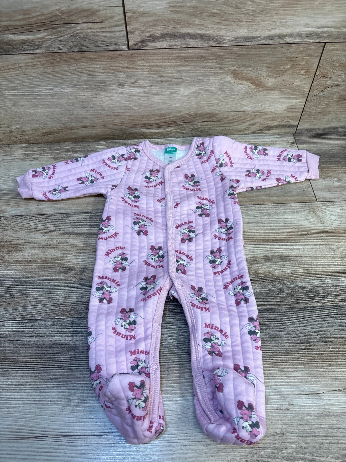 Pink Minnie Mouse baby sleeper on wood floor, long sleeves, footed, cartoon pattern