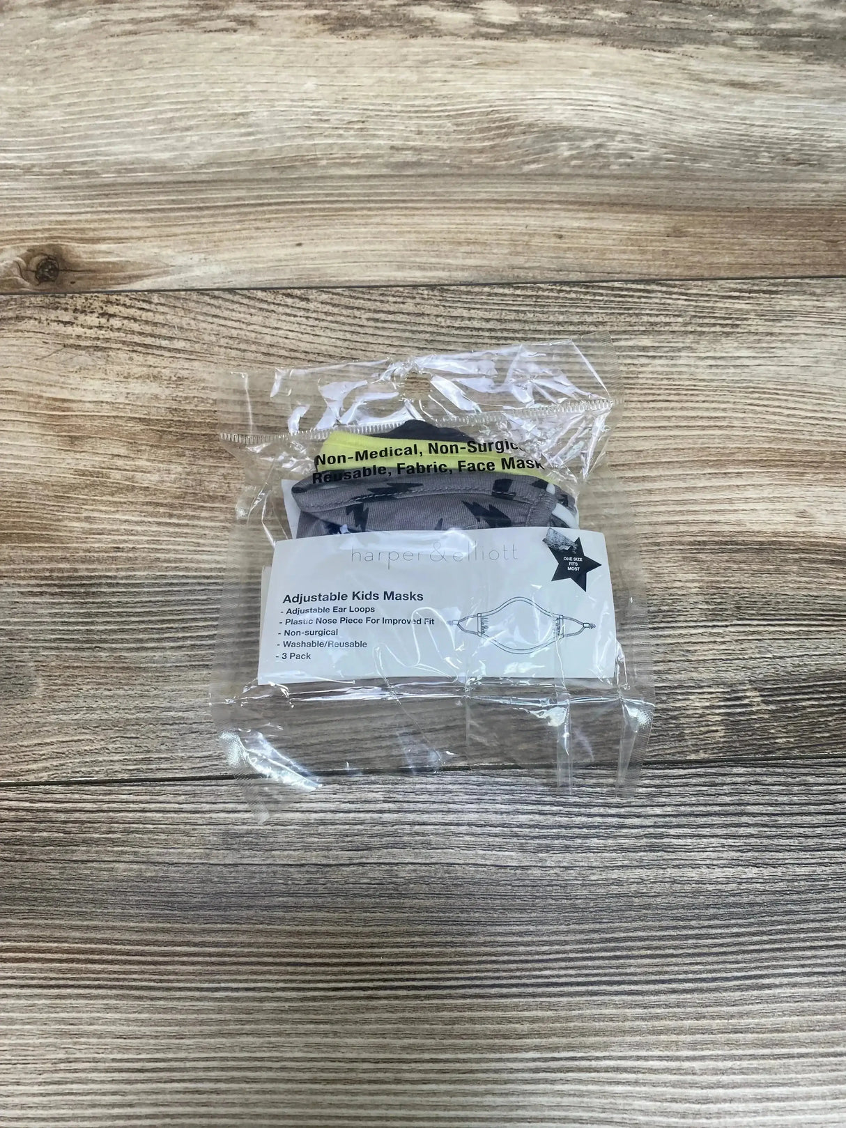 Top view of Harper & Elliott 3-pack kids masks in clear packaging, grey and green masks with adjustable ear loops on wood