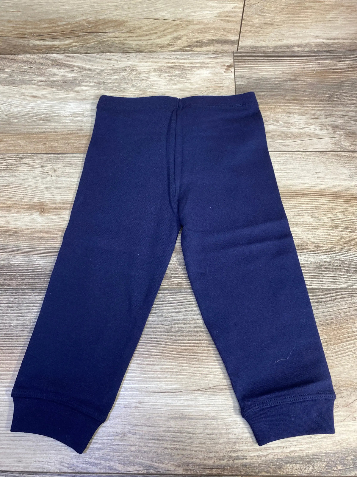 Front view of navy Primary Leggings in size 12-18m showcasing full-length legs and elastic cuffs on a wooden floor