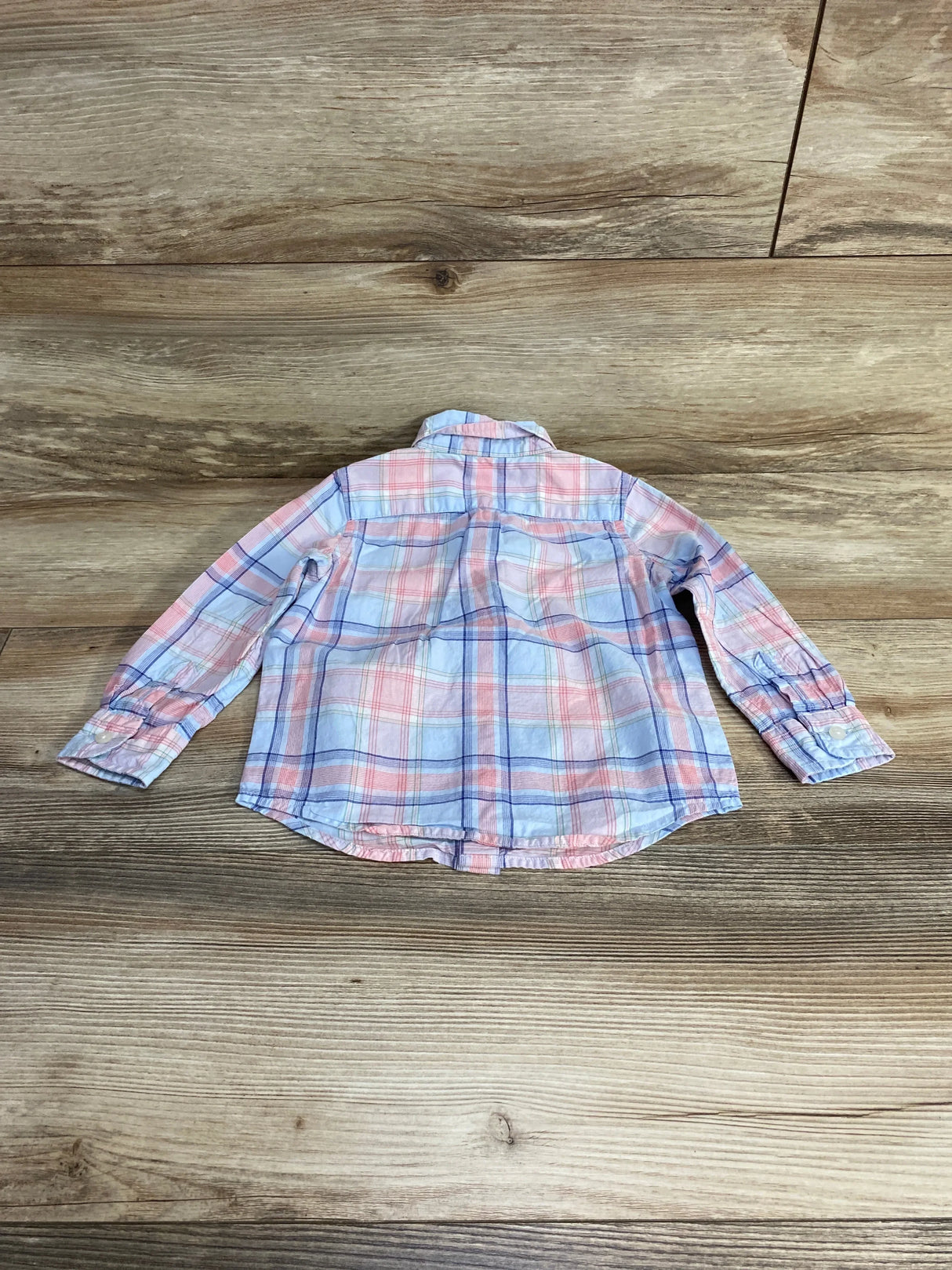 Flat-lay back view of Janie and Jack plaid button-down shirt in blue and pink showing chest yoke and sleeves on wood floor