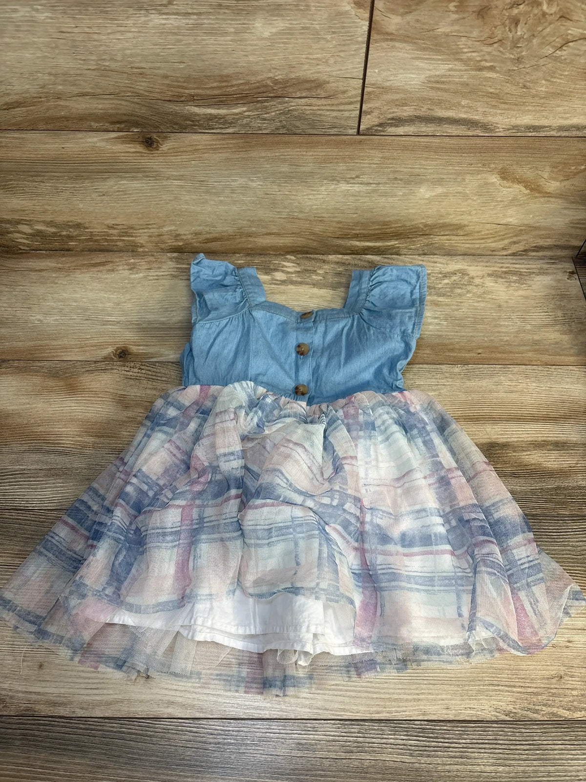 Girls sleeveless blue chambray dress with plaid tulle skirt on wood background