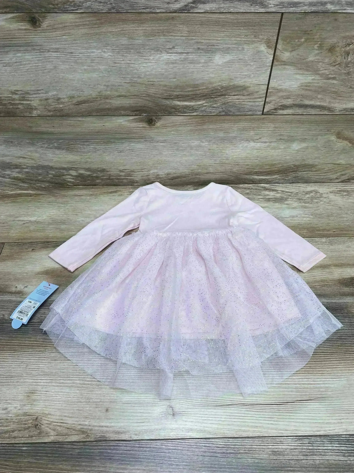 Flat lay of Cat and Jack tulle dress with bloomers showing long sleeve and glittery pink layered tulle skirt on wood floor