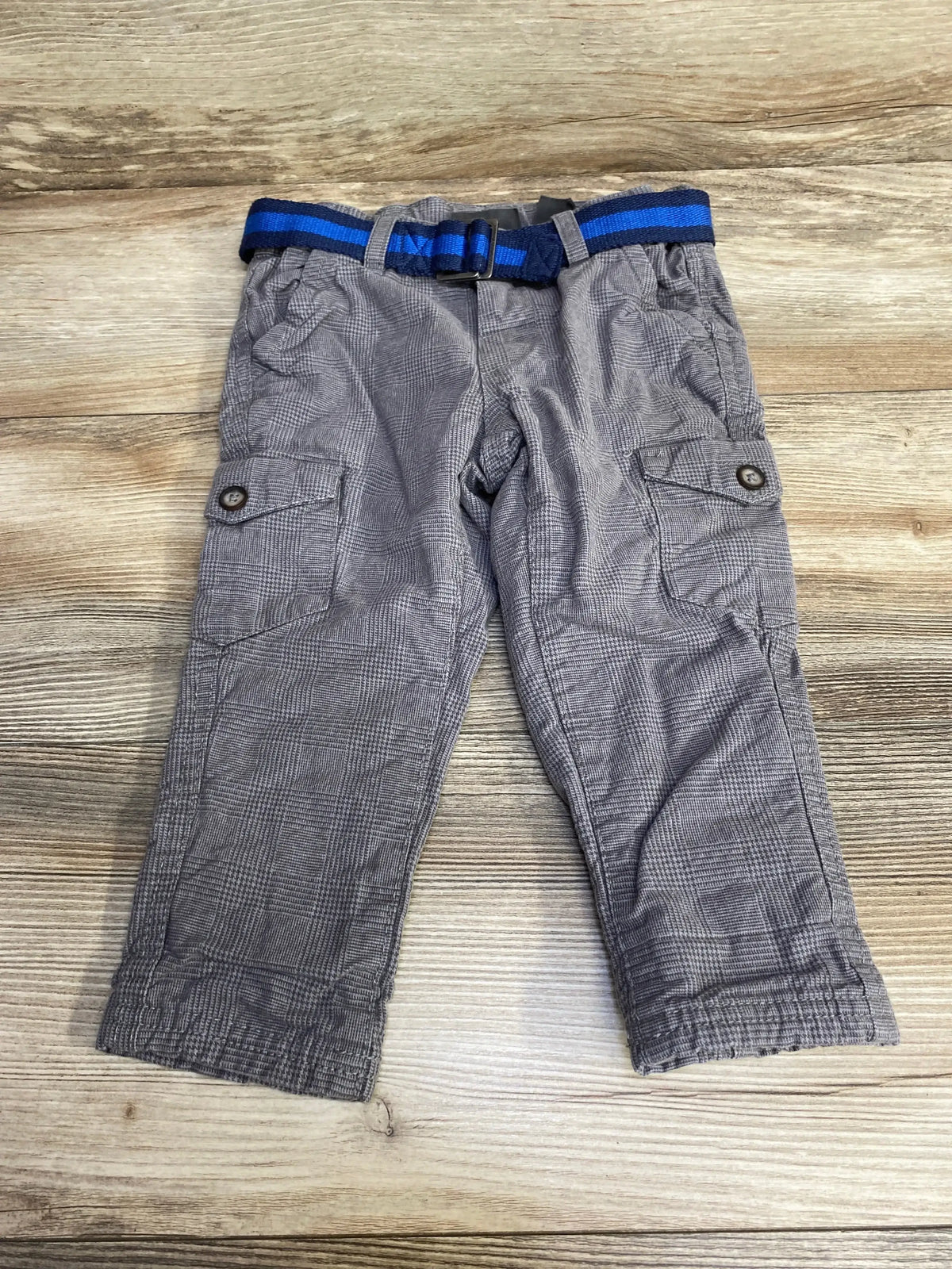Flat lay of H&M toddler lined grey pants showing blue striped belt, cargo pockets, elasticized cuffs on wood background