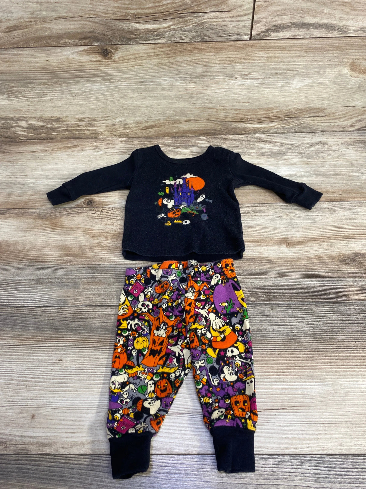 Kids Halloween pajama set with spooky castle and cartoon characters on black top and colorful pants
