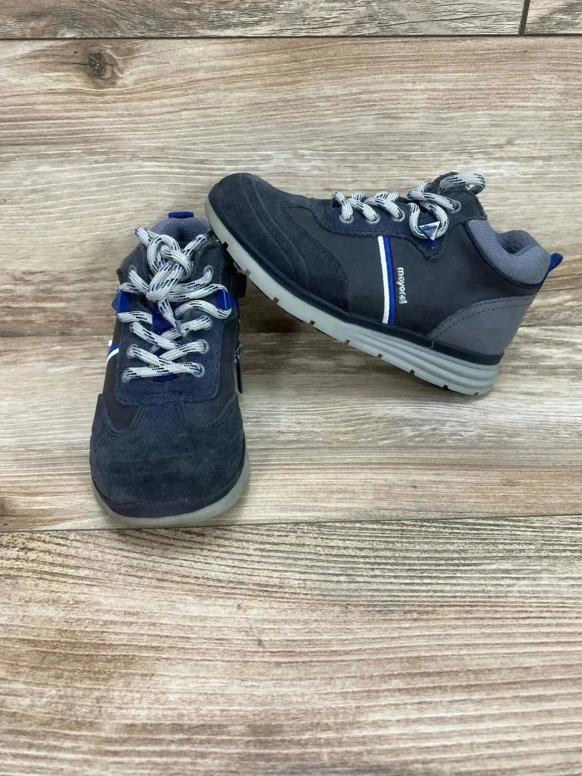 Front and side of Mayoral Colorblock City sneaker, gray size 12C, lace-up with blue stripe and light gray sole on wood
