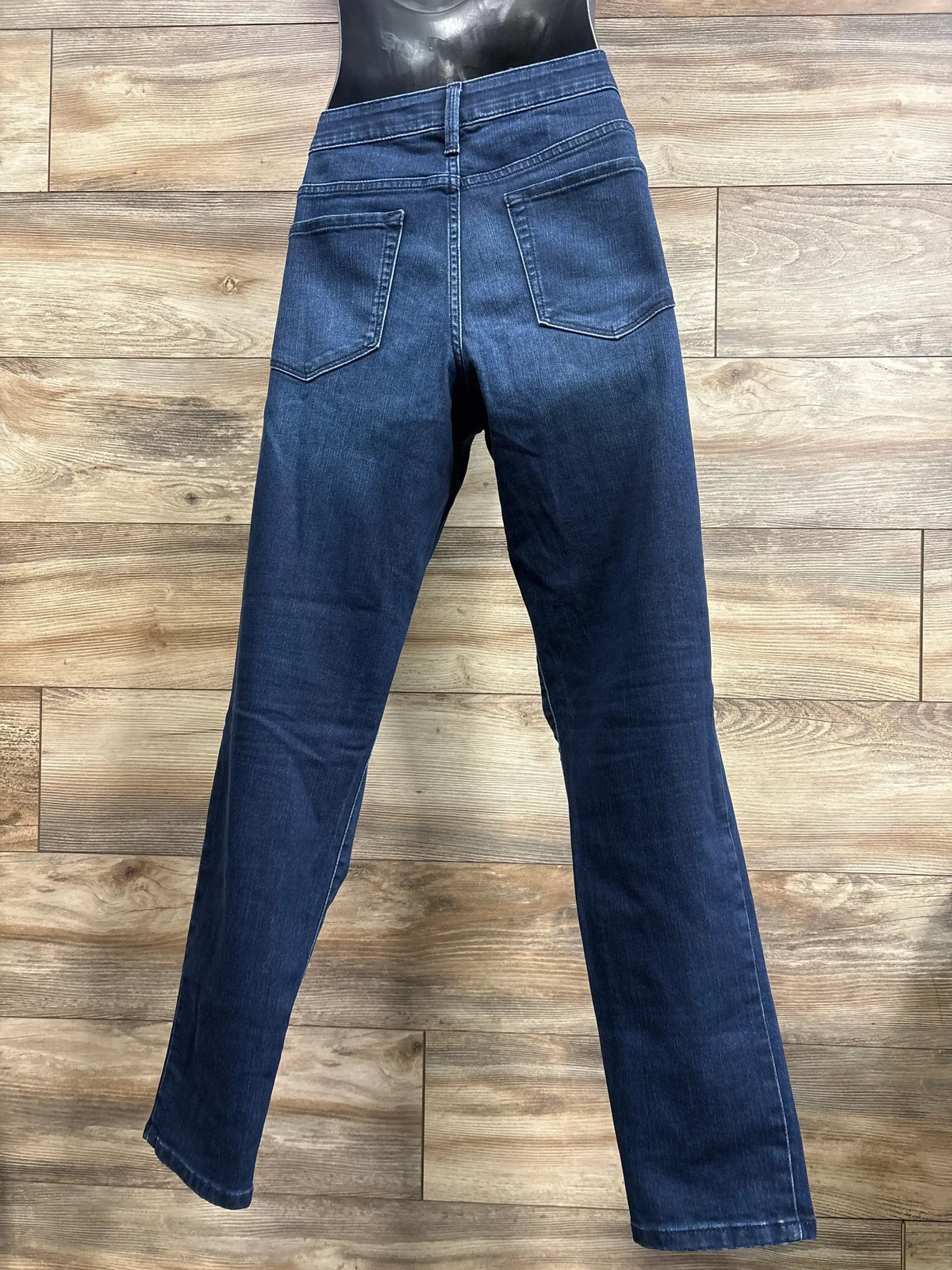 Back view of Isabel Maternity side panel skinny jeans in dark navy denim showcasing back pockets and slim leg on mannequin over wood plank floor