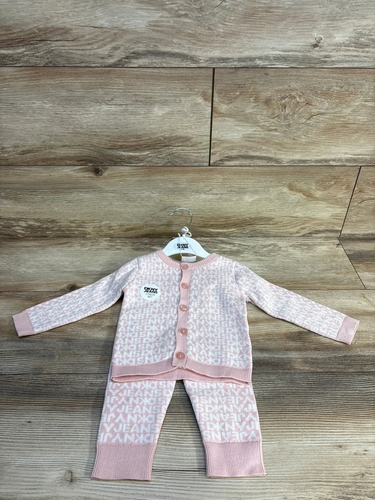 Pink DKNY Jeans baby 2-piece set with logo pattern, soft knit cardigan and pants on hanger