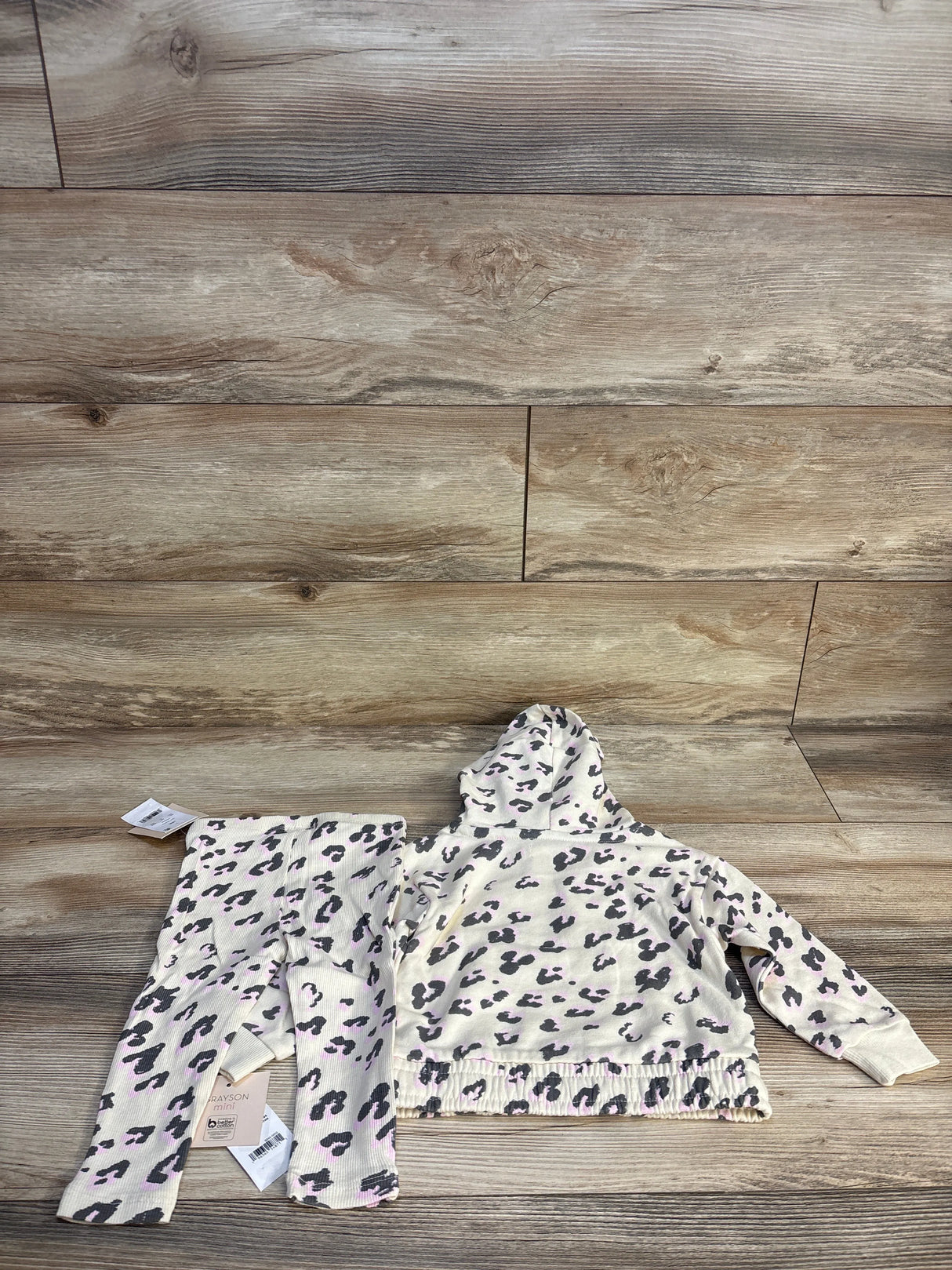 Toddler girl leopard print hoodie and pants set on wood background