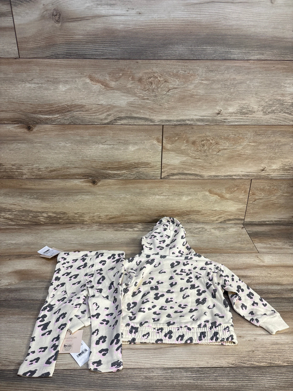 Toddler girl leopard print hoodie and pants set on wood background