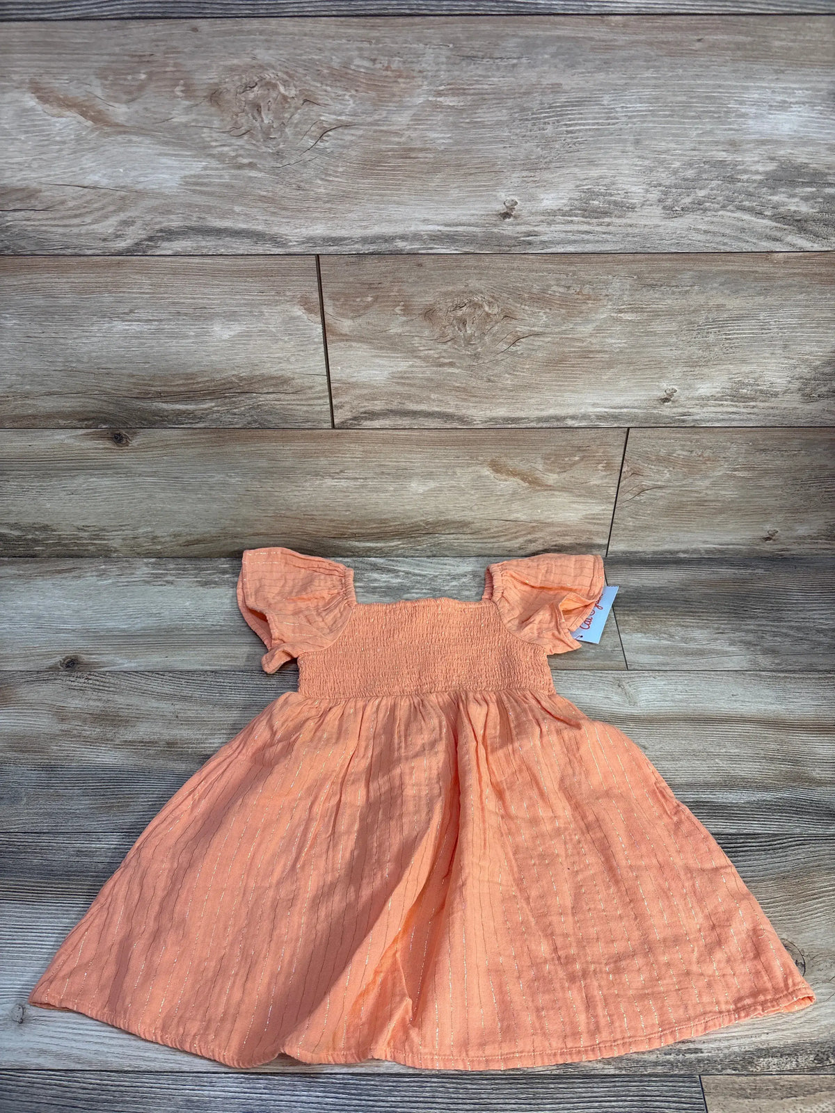 Cat and Jack size 4T peach orange short sleeve dress showcasing gold stripes and smocked bodice on a wood floor