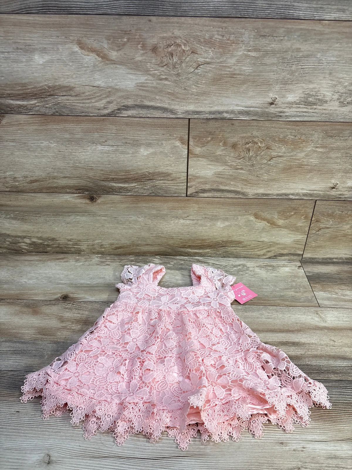 New Rare Editions pink lace dress for toddlers size 2T on a wooden background