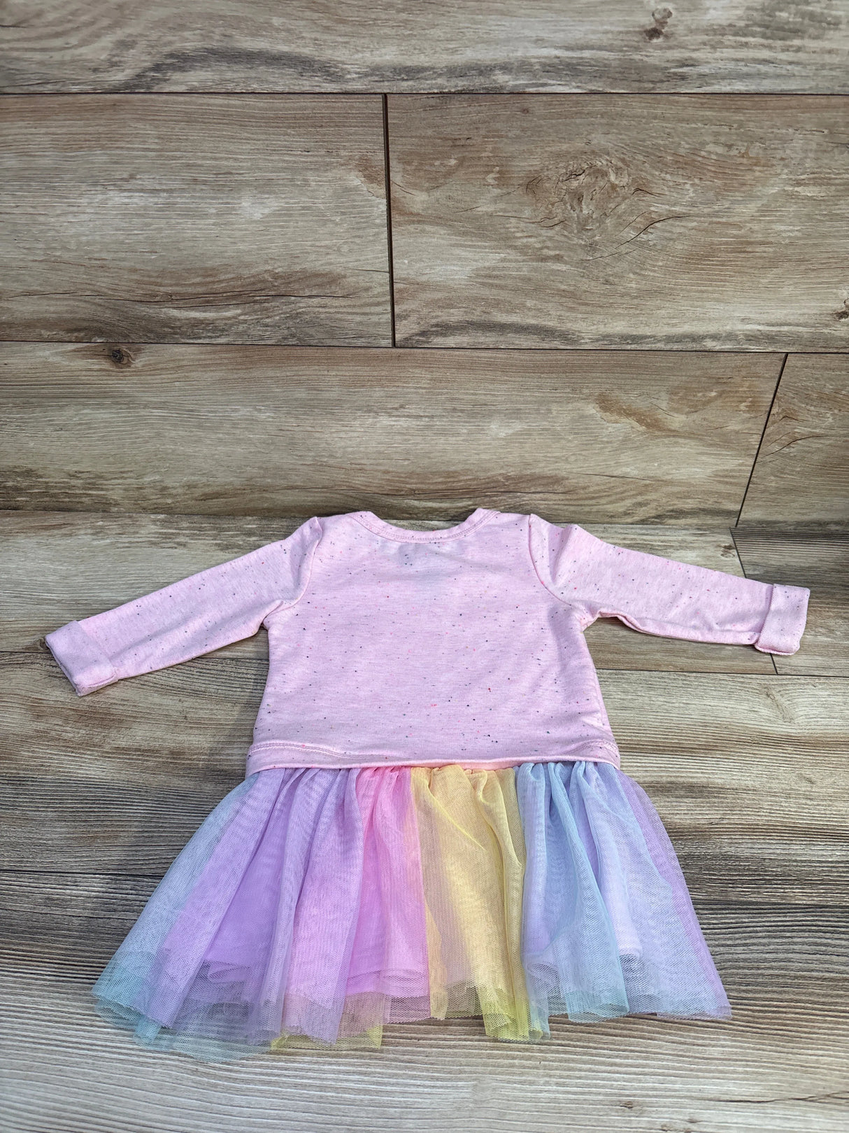 Front view of Zunie sweatshirt tulle dress showcasing pink long sleeves and multicolor tulle skirt on a wood floor
