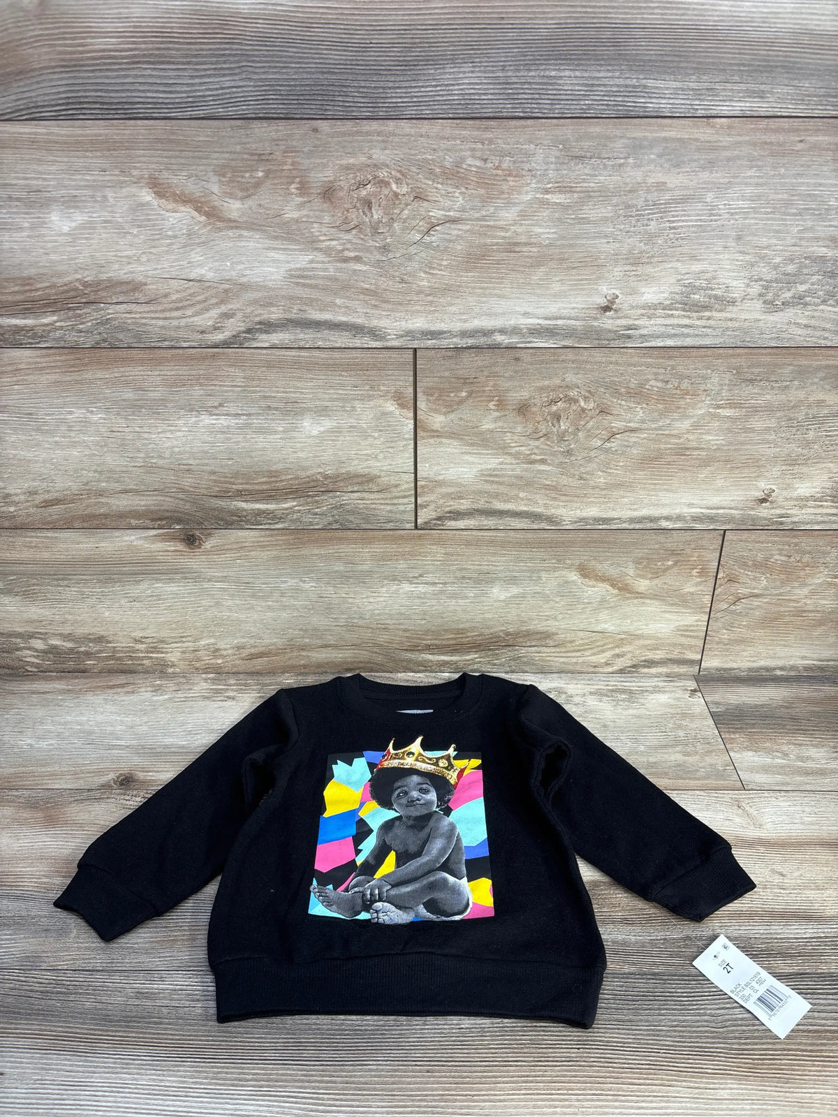 Front view of black The Notorious B.I.G. sweatshirt in size 2T, featuring a crowned child graphic against colorful geometric shapes