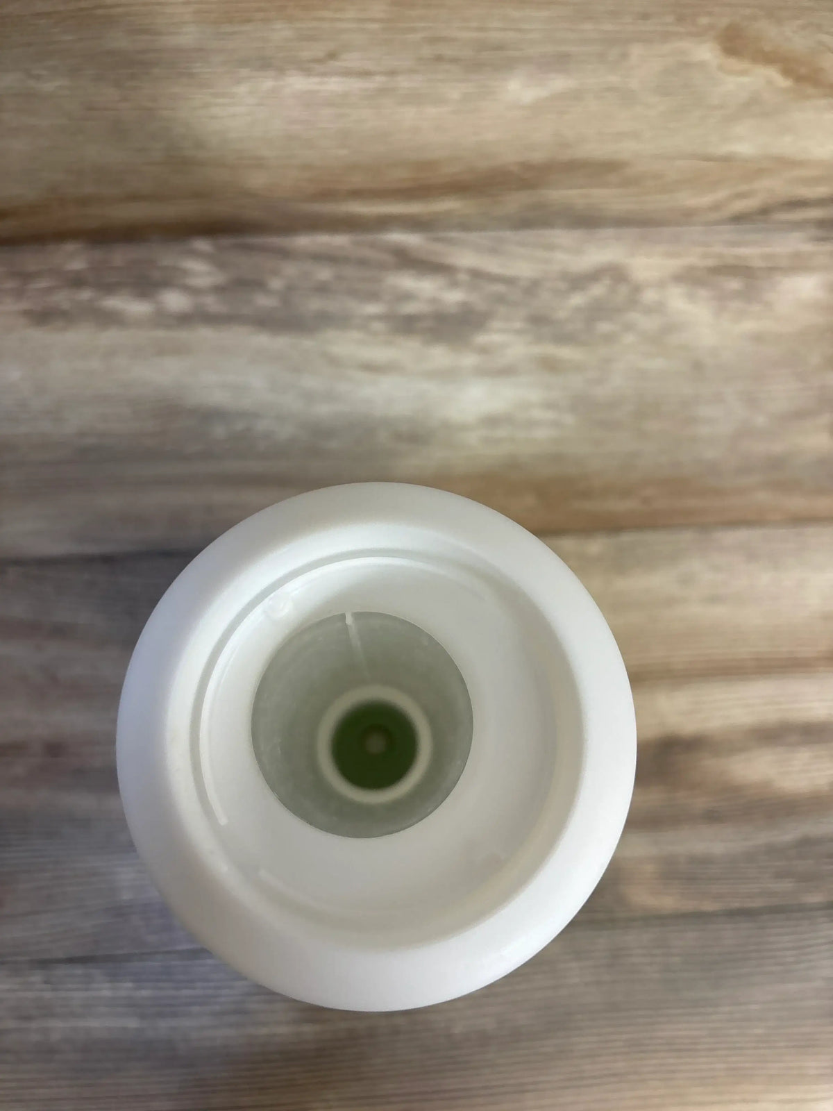 Top view of PureBaby 3-in-1 Humidifier reservoir showing green valve inside white neck on wooden surface